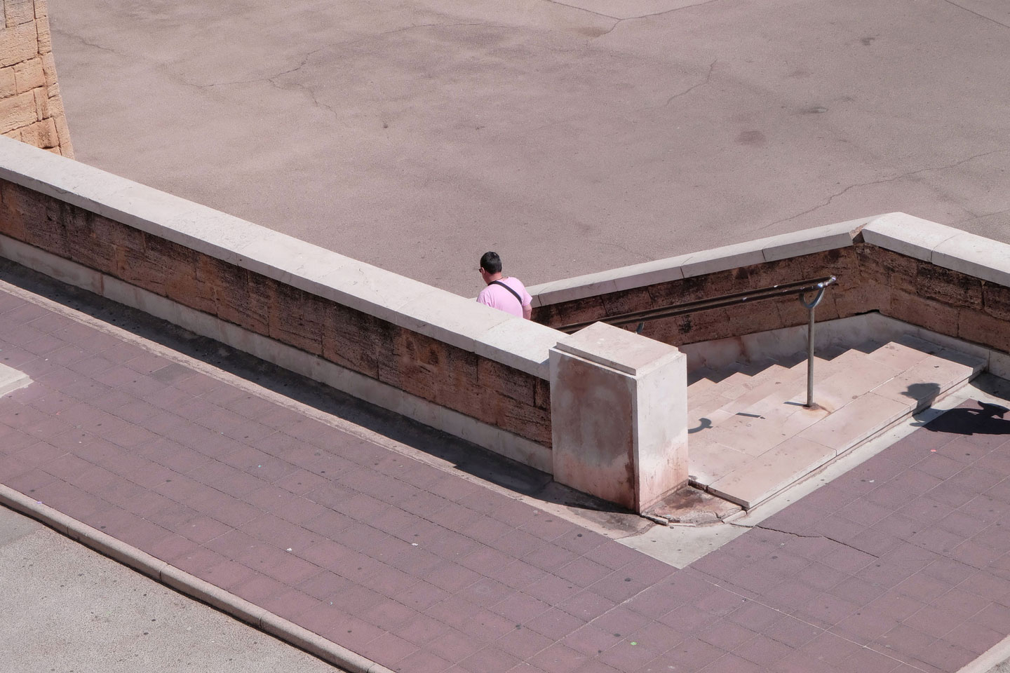 Ein Mann mit pinkem Shirt schreitet eine Treppe runter
