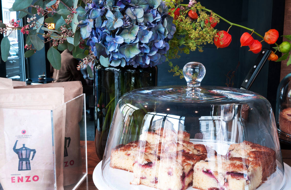 Detailansicht einer Theke mit Kuchen und farbenfrohen Blumen als Dekoration