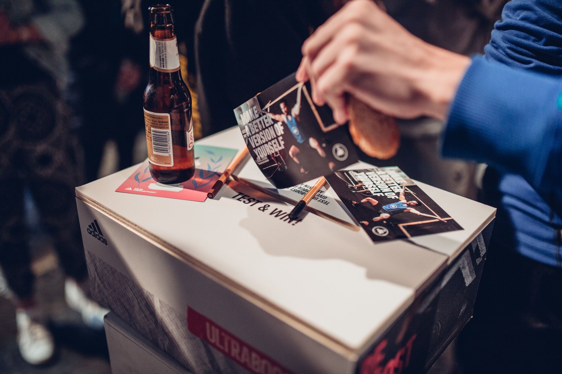 Gewinnspielbox beim Solar Boost Launch, eine Hand wirft einen Flyer in die Box